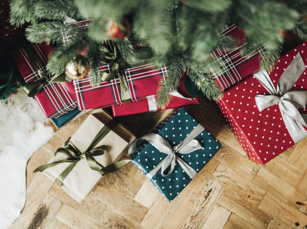 A group of presents under the christmas tree.